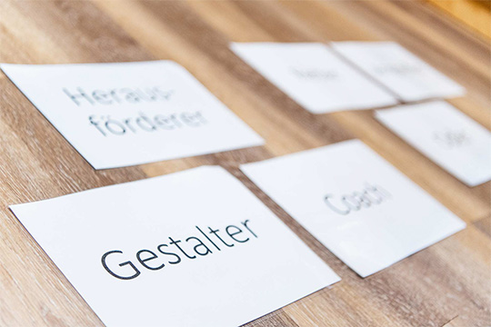 Gruppe an Figuren in einem weißen Raum